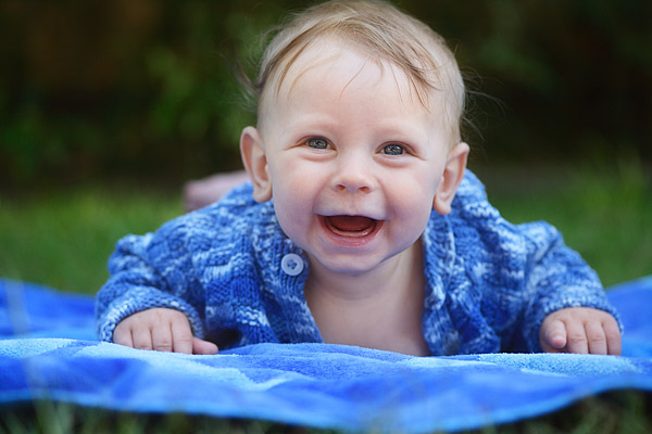 Lachendes 6 Monate altes Baby in Bauchlage